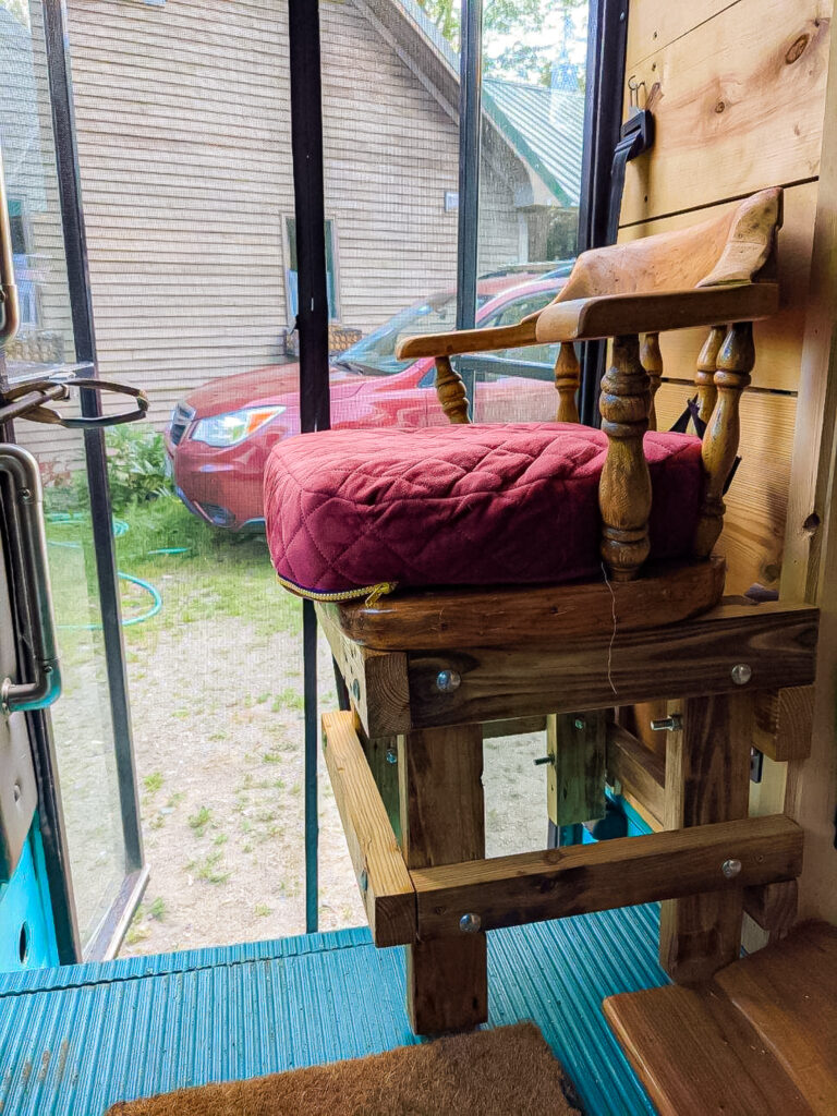 a wooden chair attached to the wooden wall inside a vehicle.